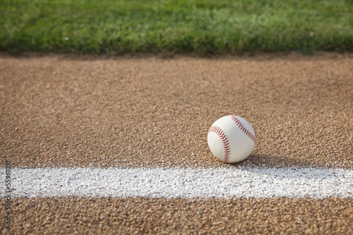 Baseball on base path with grass infield