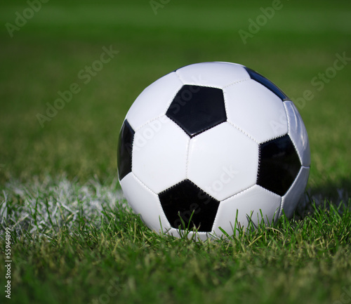 Soccer ball on the field with yard line. Football on green grass © Guzel Studio