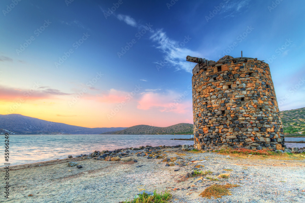 Ancient windmill ruin at sunset on Crete, Greece
