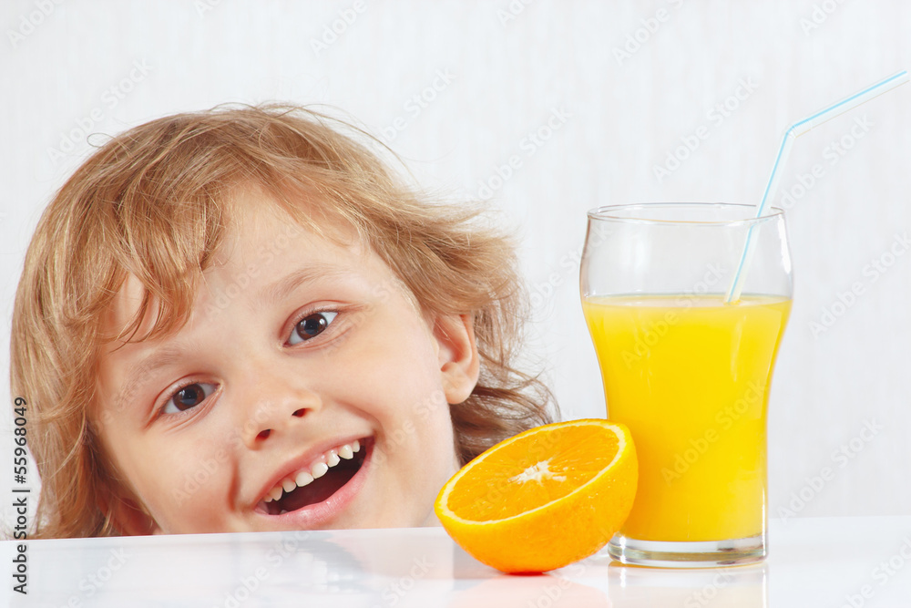 Beautiful smiling child with a glass of fresh juice and orange Beautiful smiling child with a glass of fresh juice and orange