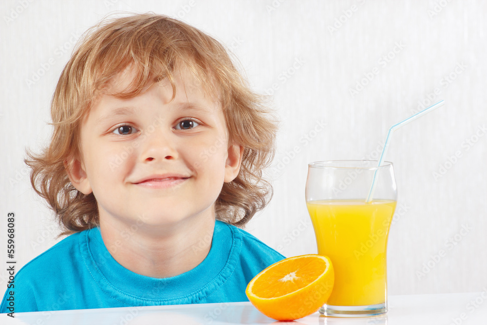Young boy with a glass of fresh juice and orange Young boy with a glass of fresh juice and orange