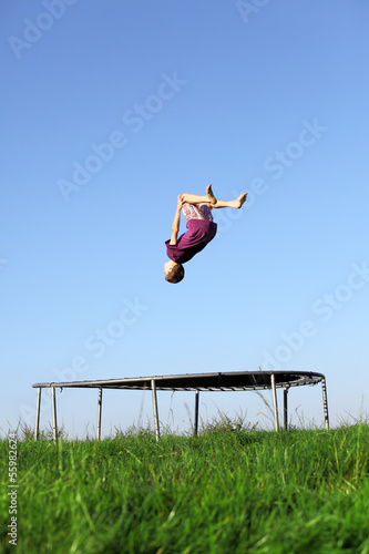 Sportlicher Junge macht einen Salto auf dem Trampolin