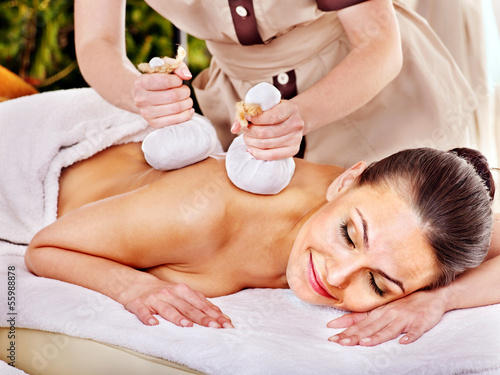 Woman getting herbal ball massage treatments . photo