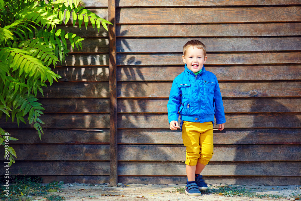 cute fashionable boy in front of wooden wall cute fashionable boy in front of wooden wall