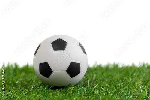 Soccer ball model on artificial green grass over white backgroun