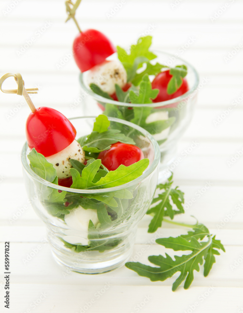 Salad with arugula, mozzarella and tomatoes. Salad with arugula, mozzarella and tomatoes.