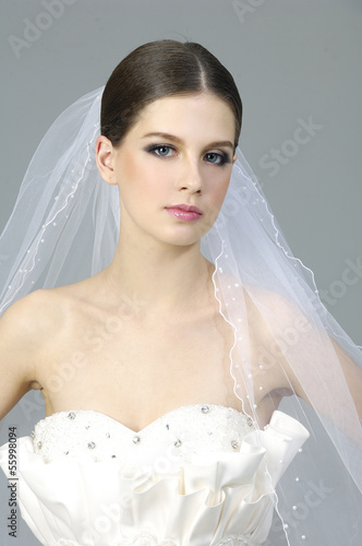 Portrait of cute young bride wearing the white vial