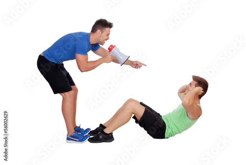 Personal trainer with a megaphone and boy making abdominal