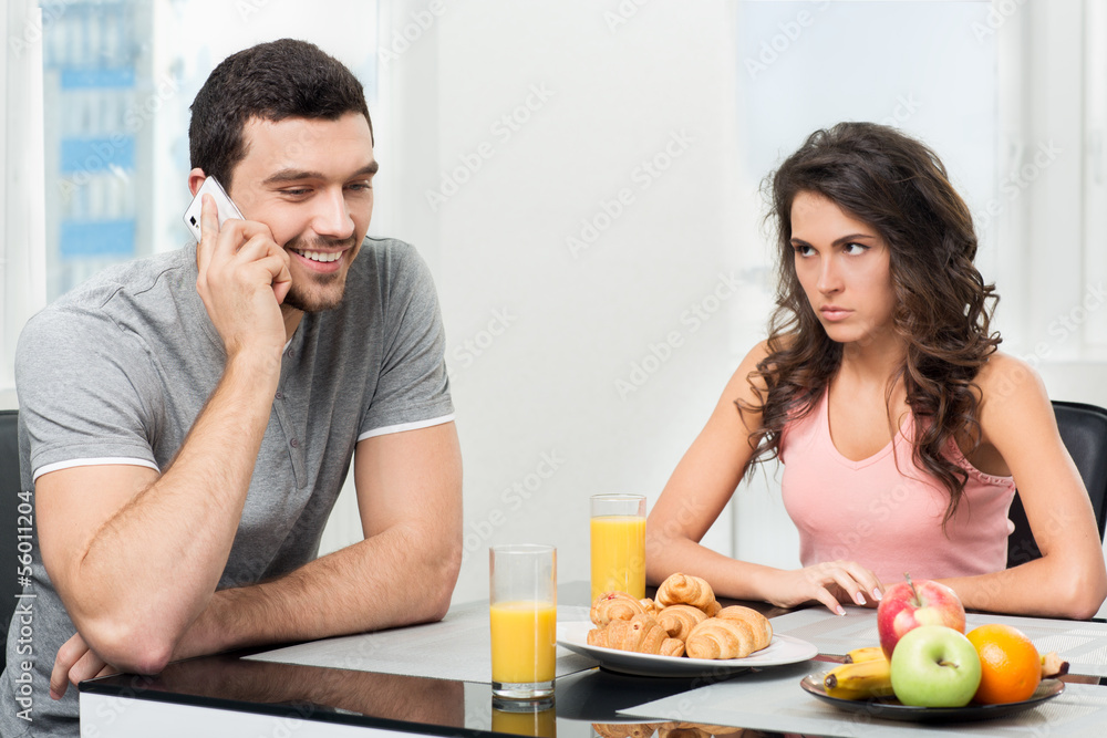 couple having breakfast, guy talking on the phone