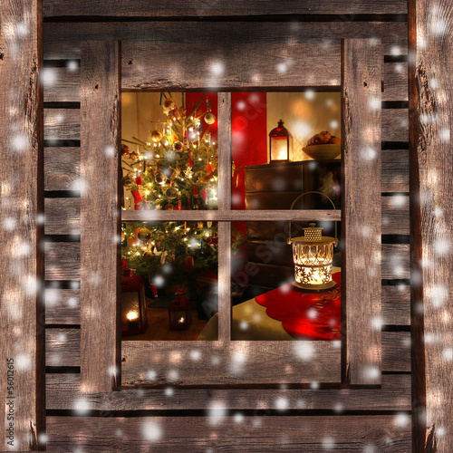 Obraz na płótnie Christmas tree and fireplace seen through a wooden cabin window w salonie