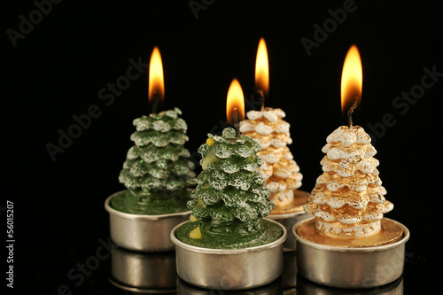 Cute candles on black with reflection