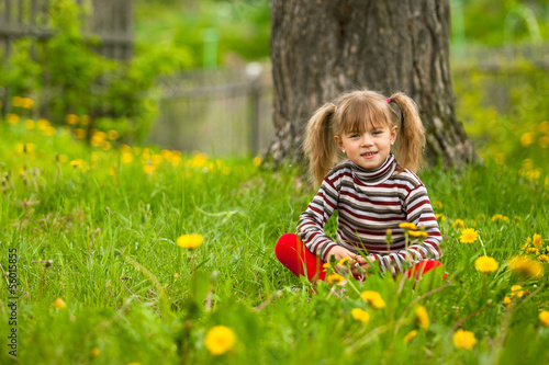 Lovely five-year girl sitting in grass
