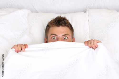 Handsome young man in bed