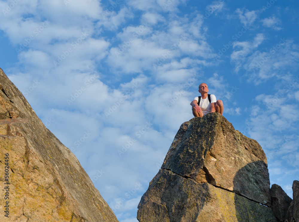 Man sitting on top of a mounain Man sitting on top of a mounain