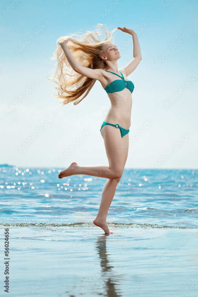 Fototapeta premium Beautiful woman on the beach by the sea