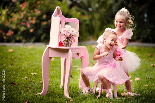 two happy little girl wearing in princess cotumes have a fun in photo