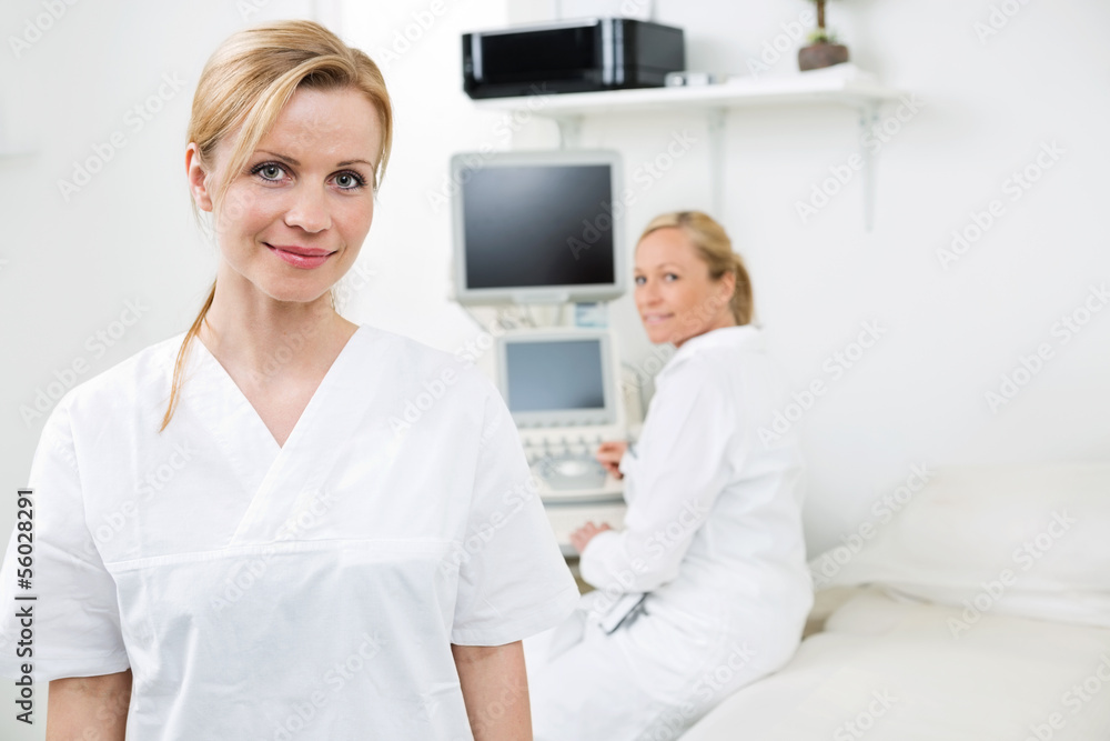 Obraz premium Happy Female Gynecologist With Colleague In Background