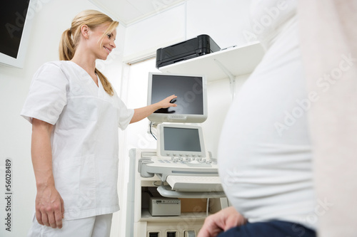 Gynecologist Showing Ultrasound Scan To Pregnant Woman
