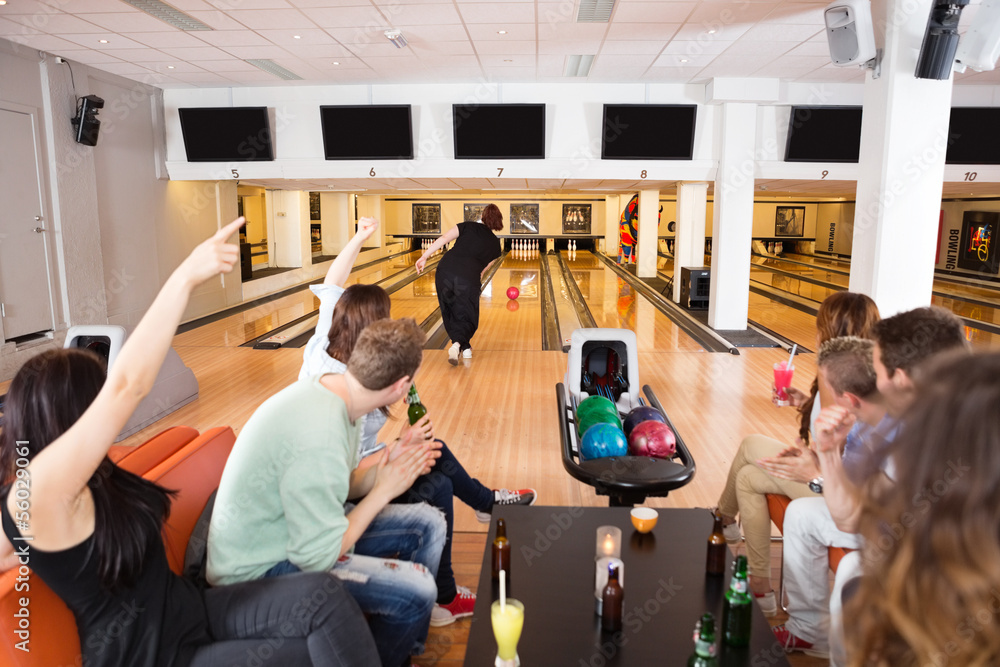 Fototapeta premium Friends Cheering Woman Bowling in Club