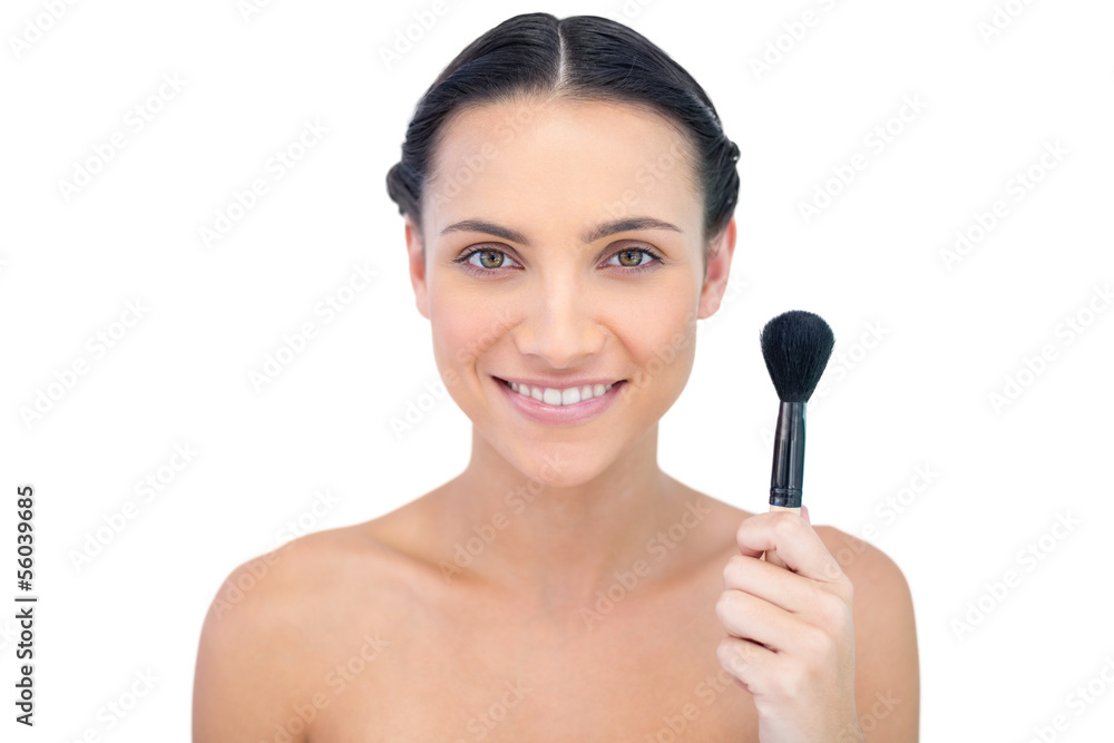 Cheerful natural model holding powder brush Cheerful natural model holding powder brush