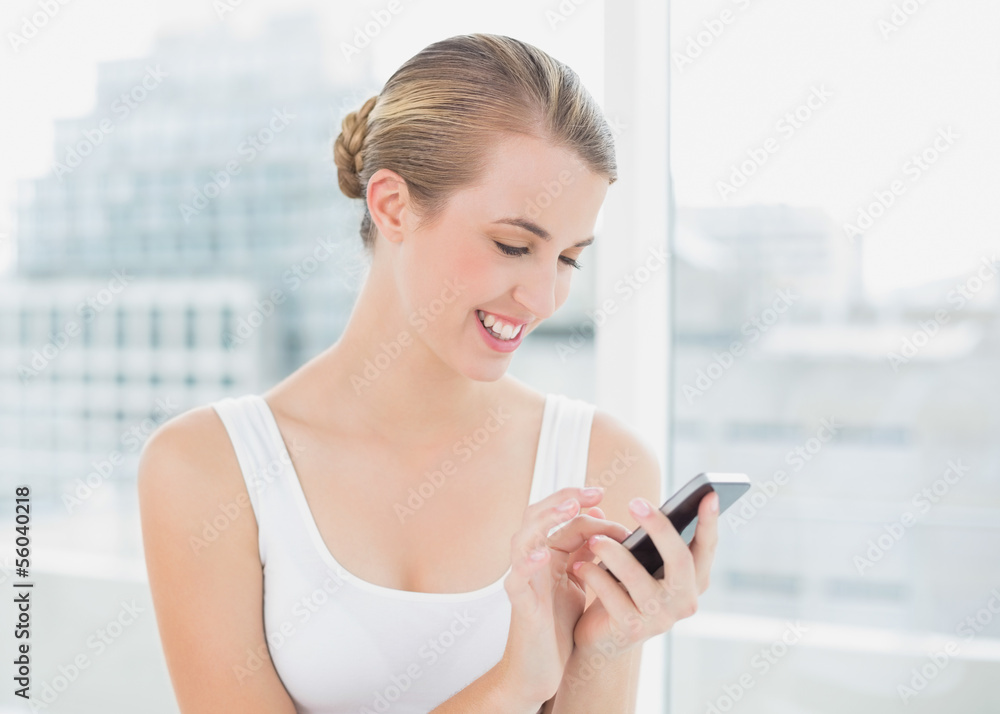 Cheerful blond woman text messaging Cheerful blond woman text messaging