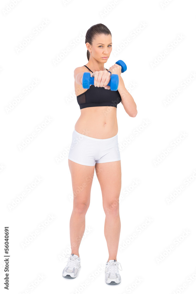 Serious fit woman working out with dumbbells Serious fit woman working out with dumbbells