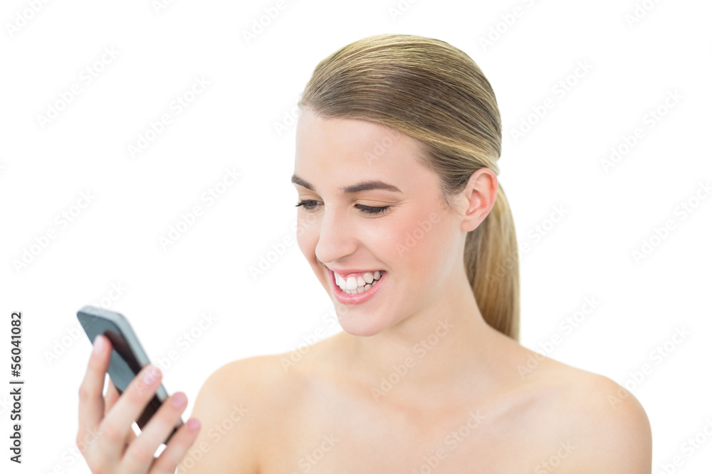 Happy attractive blonde reading a message on her smartphone Happy attractive blonde reading a message on her smartphone