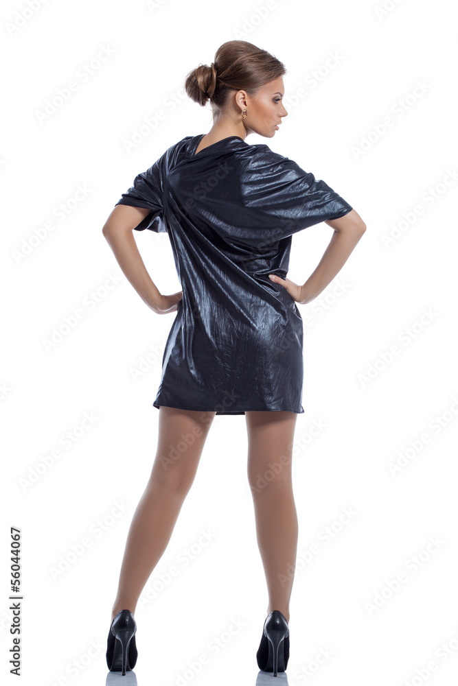 Fototapeta premium Cute girl in dark blue dress posing back to camera