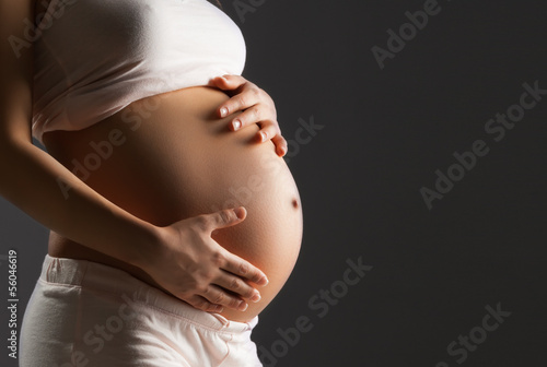 Fototapeta Pregnant woman caressing her belly