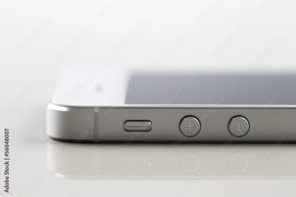 A new white smartphone on a white reflective background A new white smartphone on a white reflective background