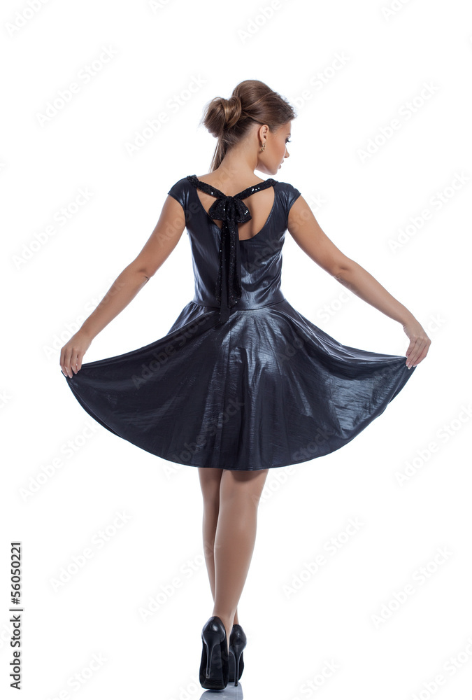 Slender woman in sexy dress posing back to camera Slender woman in sexy dress posing back to camera