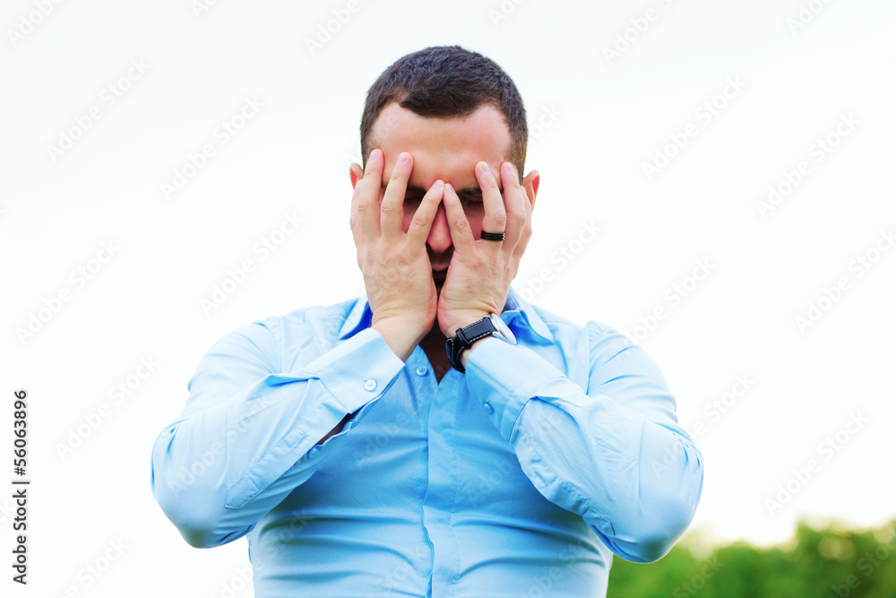 Stressed businessman covering his face with hands Stressed businessman covering his face with hands