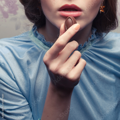 Vintage portrait of a glamorous girl in blue dress eating candy