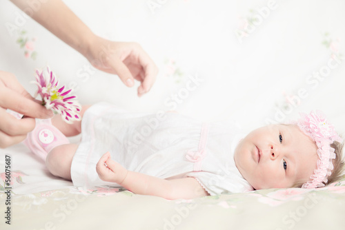 Beautiful newborn girl holding a flower