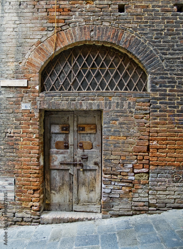 Fototapeta premium Antiqu door in Siena street. Siena, Italy