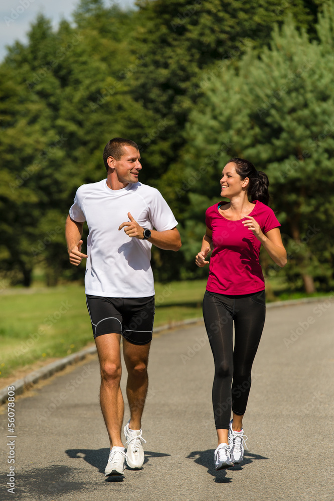 Caucasian couple running in park