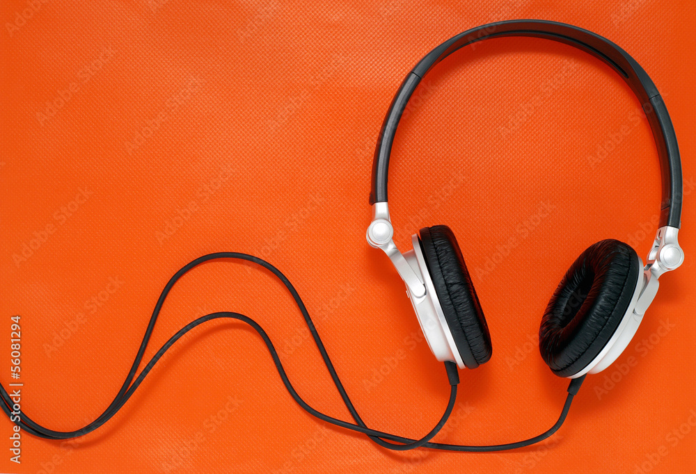 Headphones on orange background with copy space Headphones on orange background with copy space