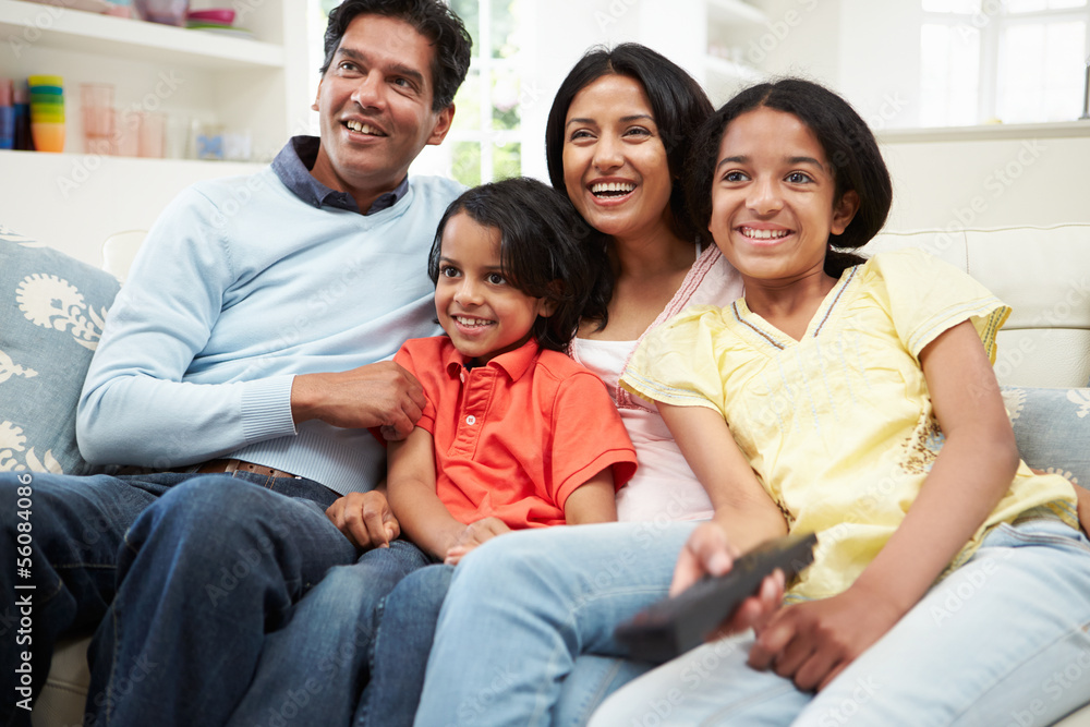 Indian Family Sitting On Sofa Watching TV Together Indian Family Sitting On Sofa Watching TV Together