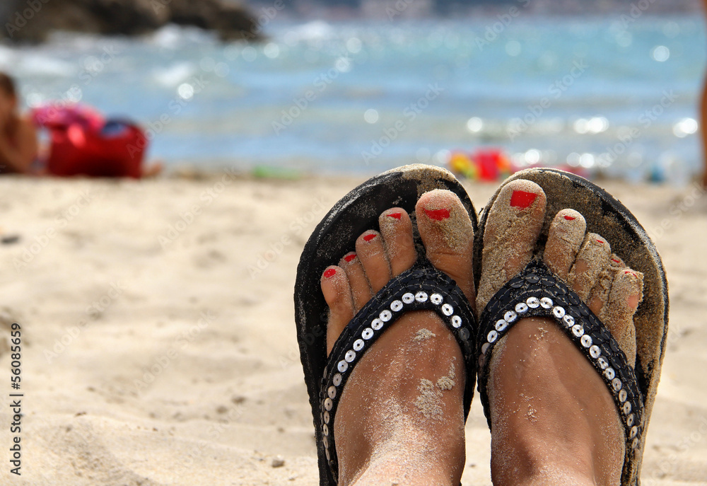 Naklejka premium Beautiful female feet on the beach