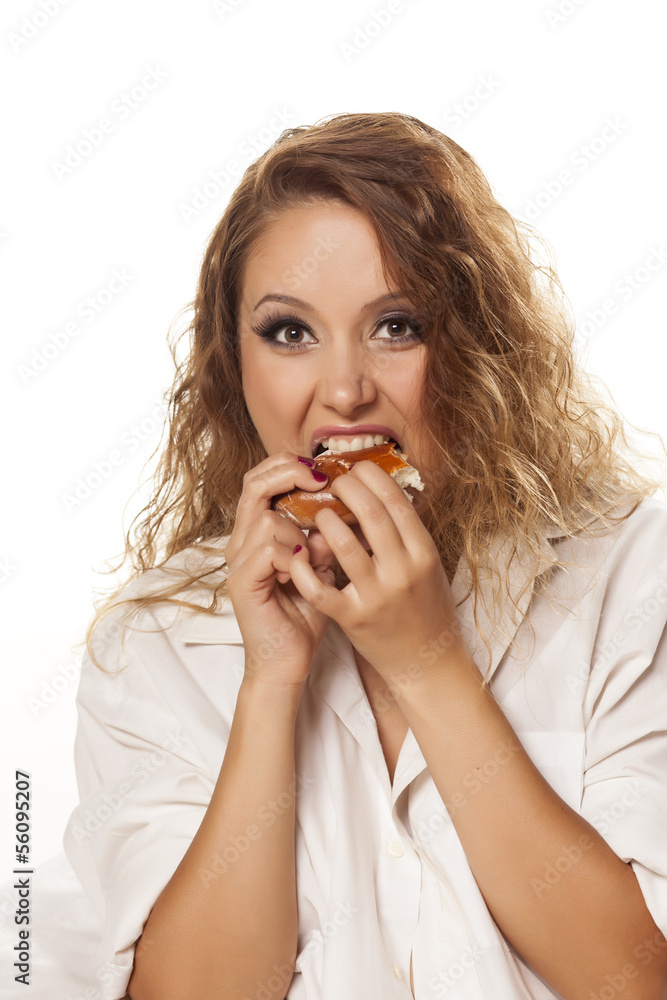 pretty hungry girl in white shirt voraciously eating donut pretty hungry girl in white shirt voraciously eating donut
