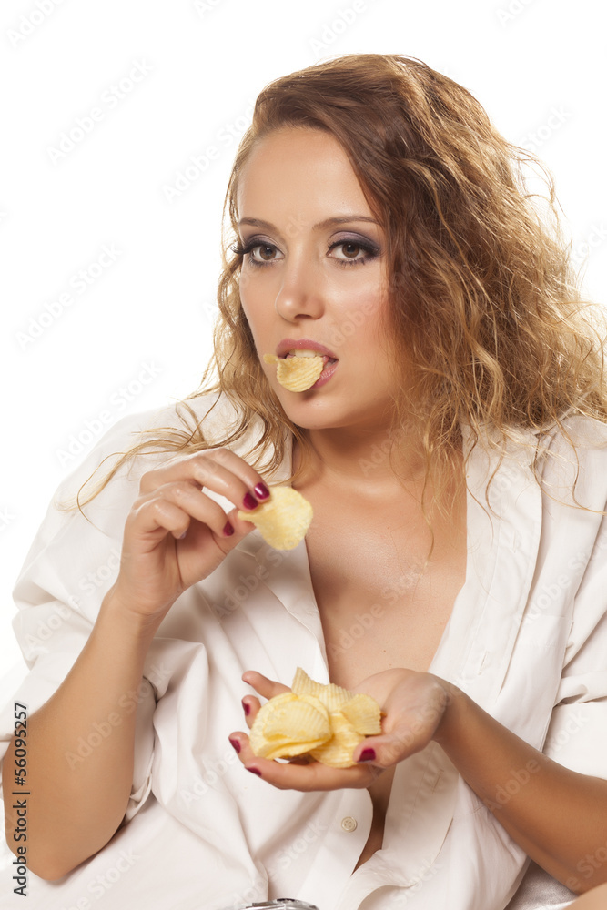 beautiful girl in a white shirt eats potato chips beautiful girl in a white shirt eats potato chips