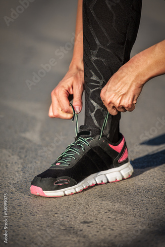 women tied the laces on the shoe before training