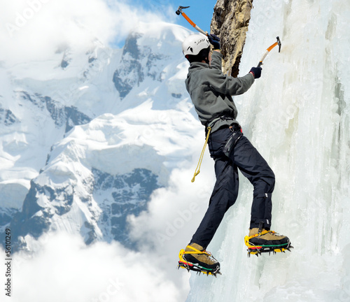 Fotografie Man climbing on icefall in winter mountains