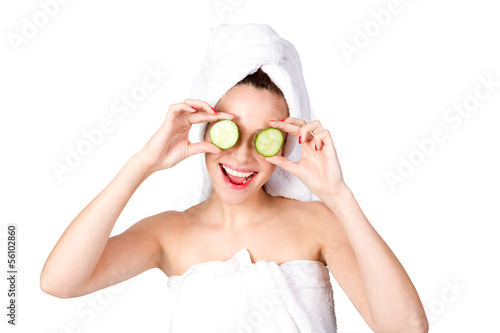 Lachende junge Frau mit Gurken vor den Augen