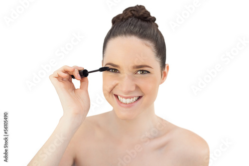 Cheerful pretty model applying mascara