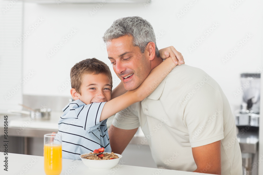 Little boy giving hug to his father during breakfast Little boy giving hug to his father during breakfast