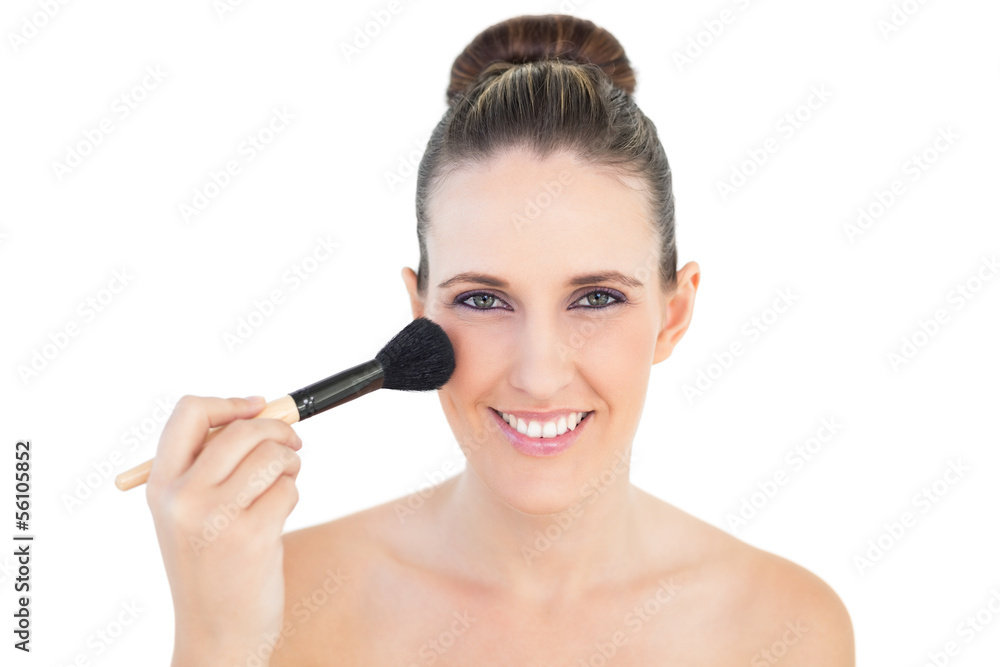 Portrait of delighted woman using blusher brush Portrait of delighted woman using blusher brush