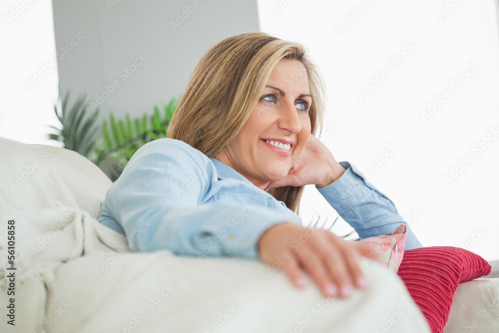 Happy woman lying on a sofa