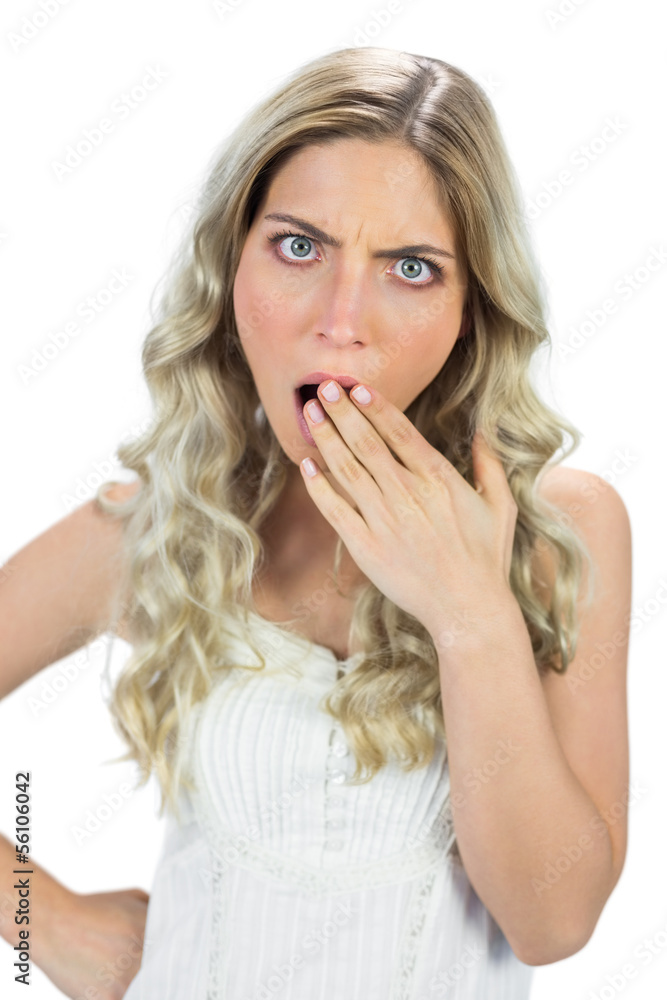 Shocked blond model hiding her mouth wide open Shocked blond model hiding her mouth wide open