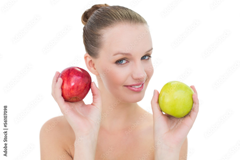 Smiling pretty blonde model holding two apples Smiling pretty blonde model holding two apples